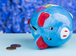 piggy bank on its side with a couple of coins
