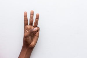 hand holding up three fingers number 3